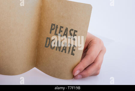 Hand mit einem Blatt Papier mit bitte Wortlaut spenden Stockfoto