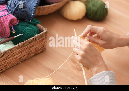 Junge Frau am Tisch sitzen und stricken warme Pullover, Nahaufnahme Stockfoto