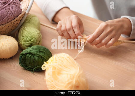 Junge Frau am Tisch sitzen und stricken warme Pullover, Nahaufnahme Stockfoto