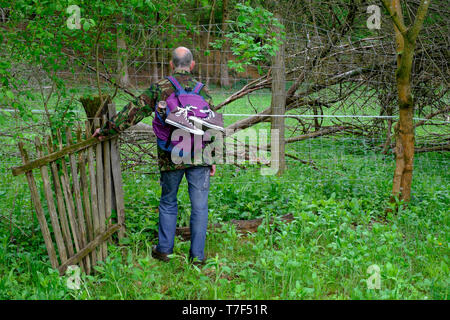 Ältere Mann mit dem Rucksack in der Landschaft steht die alte hölzerne Tor und durch die Rehe und elektrische Zäune blockieren den Weg zala Ungarn konfrontiert Stockfoto