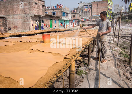 Männliche Arbeiter wird gesehen, wie er malt Leder mit Spritz- Maschine in der Lederverarbeitung (Gerbereien) in Dhaka, Bangladesh Stockfoto