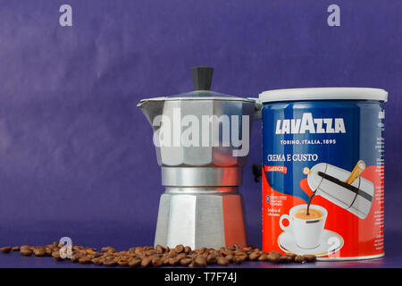 TURIN, Italien - 2. Mai 2019: Lavazza Kaffee Glas auf dem violetten Hintergrund. Moka Topf und Lavazza Kaffee Paket, TURIN, ITALIEN. Eine erläuternde Editorial Ich Stockfoto