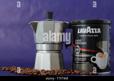 TURIN, Italien - 2. Mai 2019: Lavazza Kaffee Glas auf dem violetten Hintergrund. Moka Topf und Lavazza Kaffee Paket, TURIN, ITALIEN. Eine erläuternde Editorial Ich Stockfoto