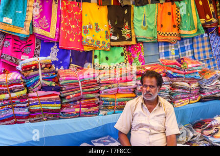 Standbesitzer sitzen an einem Stall Verkauf von Stoffen in eine lokale Markthalle in Shahpura, dindori Bezirk der zentralen indischen Bundesstaat Madhya Pradesh Stockfoto