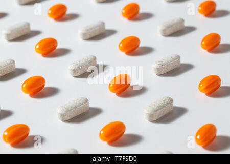 Closeup weiß und orange Pillen gegen den weißen Hintergrund. Stockfoto