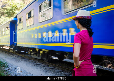 Touristen auf der Suche an einem PeruRail Blue Train in Bewegung auf der Bahn nach Aguas Calientes und Machu Picchu, Peru Stockfoto