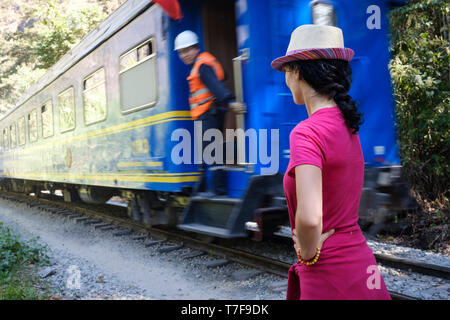 Touristen auf der Suche an einem PeruRail Blue Train in Bewegung auf der Bahn nach Aguas Calientes und Machu Picchu, Peru Stockfoto