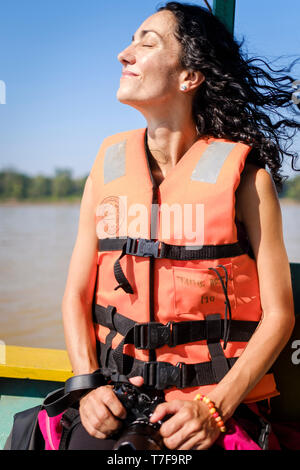 Weißer junge Frau das Tragen einer Schwimmweste genießen den Ausflug mit dem Boot auf dem Fluss Madre de Dios Fluß, Amazonas, Peru Stockfoto