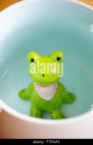 Cute frog Figurine in die weiße Tasse mit Babyblue base Stockfoto