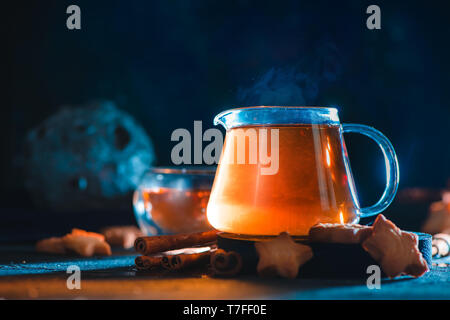 Star cookies mit Teekanne aus Glas auf einem dunklen Hintergrund mit einem Meteoriten. Kreative essen Fotografie mit einem Astronomie Thema. Stockfoto