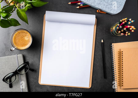 Designkonzept - Ansicht von oben kopieren Raum mit A4-Papier, Topfpflanze, Gläser, Kaffee, Bleistift auf schwarzen Hintergrund für mockup. echte Fotos und nicht für 3D-Rendering Stockfoto