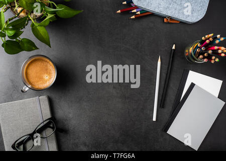 Designkonzept - Ansicht von oben kopieren Raum mit Topfpflanzen, Gläser, Kaffee, Bleistift auf schwarzen Hintergrund für mockup. echte Fotos und nicht für 3D-Rendering Stockfoto