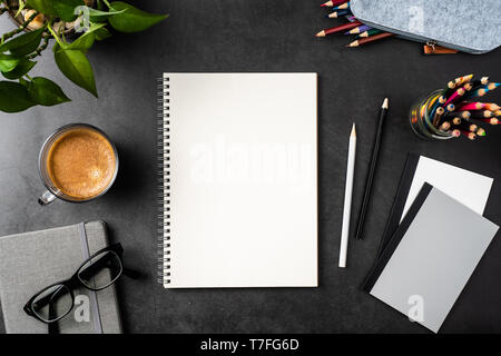 Designkonzept - Ansicht von oben kopieren Raum mit Spirale notebook, Topfpflanze, Gläser, Kaffee, Bleistift auf schwarzen Hintergrund für mockup. echte Fotos und nicht für 3D Stockfoto