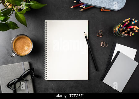 Designkonzept - Ansicht von oben kopieren Raum mit Spirale notebook, Topfpflanze, Gläser, Kaffee, Bleistift auf schwarzen Hintergrund für mockup. echte Fotos und nicht für 3D Stockfoto