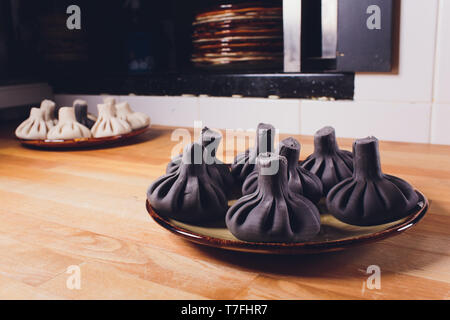 Schwarz georgischen Knödel Khinkali mit Fleisch auf weiße Platte. Stockfoto