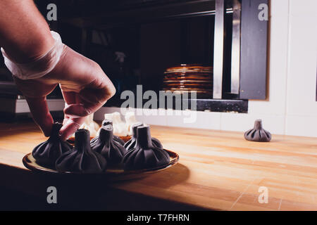 Schwarz georgischen Knödel Khinkali mit Fleisch auf weiße Platte. Stockfoto