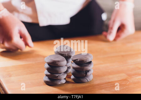 Nationale georgische Küche Khinkali. Ältere Frau bereitet khinkali. Ansicht von oben rohes Fleisch Teig Teller ungekocht. Prozess kochen schwarze Farbe. Stockfoto