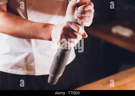 Nationale georgische Küche Khinkali. Ältere Frau bereitet khinkali. Ansicht von oben rohes Fleisch Teig Teller ungekocht. Prozess kochen schwarze Farbe. Stockfoto