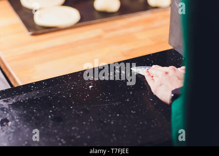 Kellner Reinigung der Tabelle mit Desinfektionsmittel Spray in einem Restaurant. Stockfoto