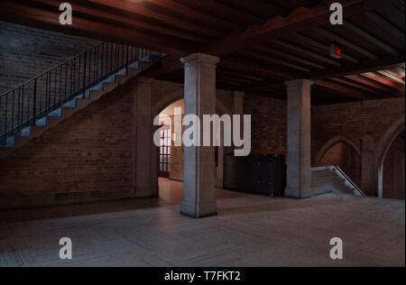 Innenansicht eines alten Gebäudes mit Spalten und Treppe mit einige Lichtstrahlen in dunkler Umgebung Stockfoto