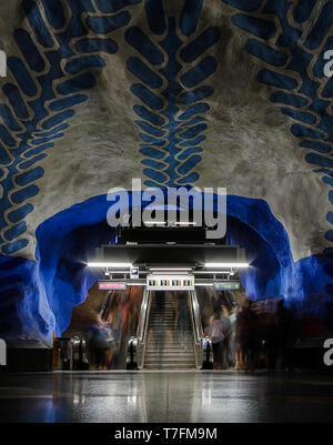 Blau Muster an der Decke der U-Bahn Station und Menschen durch Rolltreppen in Stockholm, Schweden, Stockfoto