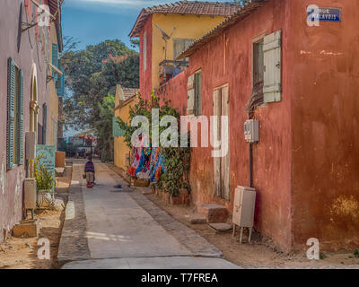 Goree, Senegal - Februar 2, 2019: Alltag und Straße mit Kopfsteinpflaster Straße zwischen Bunte Häuser auf der Insel Goree. Gorée. Dakar, Seneg Stockfoto