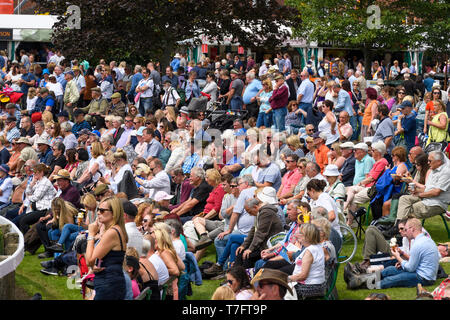 Viele Menschen zuschauen, um Main Arena versammelten sich entspannen, sitzen in der Sonne und beobachtete Ereignis - Tolle Yorkshire zeigen, Harrogate, England, UK. Stockfoto