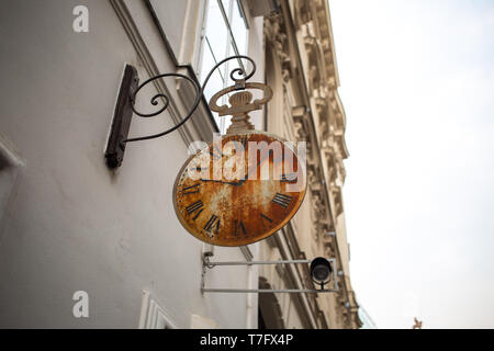 Ein Schild mit einem rostigen Taschenuhr in den Straßen in Rom, Italien Stockfoto