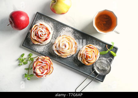 Teller mit leckeren Rose geformte Apfelkuchen auf Tisch Stockfoto