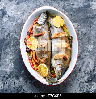 Fisch mit Gemüse und Zitrone. köstliche Forellen fischen gebacken mit Speck Stockfoto