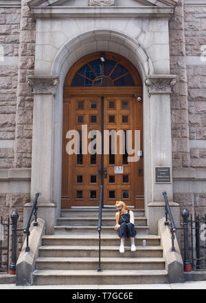 Junge Frau sitzend auf die Schritte der Kirche in Manhattan, New York City, New York, Vereinigte Staaten von Amerika Stockfoto
