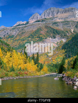 USA, Montana, Glacier National Park, Herbst Farbe am McDonald Creek mit Spitzenwerten von der Gartenmauer in der Ferne. Stockfoto