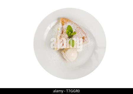 Apfelkuchen, Charlotte mit Vanilleeis, Puderzucker und Minzeblatt, serviert auf einem Teller isoliert weißer Hintergrund. Dessert für ein Menü in einem Cafe, r Stockfoto