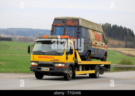 Salo, Finnland - 26 April 2019: Gelb Mitsubishi Fuso Canter Abschleppwagen trägt eine alte Gliederung van entlang der Autobahn an einem Tag des Frühlings. Stockfoto