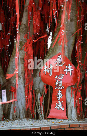 Rot, die Bänder schmückten die lokalen Baum glauben viel Glück bei Sekinchan, Malaysia zu bringen. Stockfoto