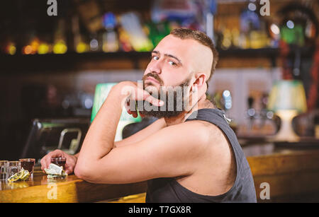 Alkoholismus und Depression. Alkohol Konzept süchtig. Hipster brutalen Mann, Alkohol zu trinken bestellen mehr Getränke an der Theke. Kerl verbringen Freizeit in bar mit Alkohol. Mann betrunken sitzen alleine in eine Kneipe. Stockfoto