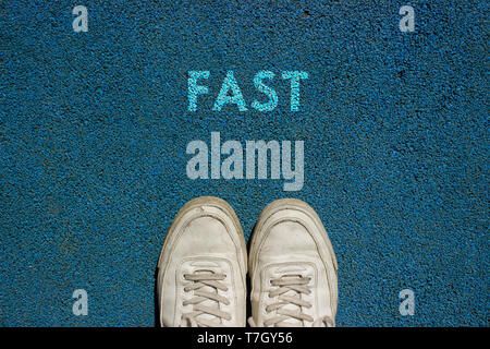 Neues Leben Konzept, Sport Schuhe und das Wort schnell zu Fuß weg Boden geschrieben, Motivations Slogan. Stockfoto