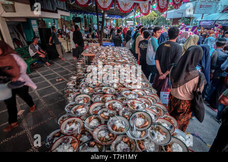 Platten von Lebensmitteln der indonesischen Muslime erfaßten für iftar (fastenbrechen) Abendessen während des heiligen Monats Ramadan bei Jogokariyan Moschee in Yogyakarta, Indonesien gesehen. Muslime auf der ganzen Welt feiern des heiligen Monats Ramadan, die von während der Nacht Zeit beten und den Verzicht auf Essen und Trinken in der Zeit zwischen Sonnenaufgang und Sonnenuntergang. Stockfoto