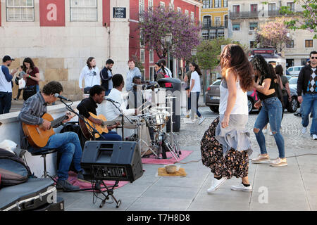 Touristen watch woman dancing in der Straße zu der Musik von einer Gruppe von Musikern spielen Gitarren Drums Alfama von Lissabon Portugal KATHY DEWITT Stockfoto