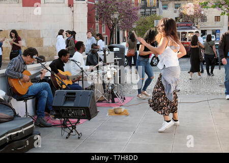 Touristen watch woman dancing in der Straße zu der Musik von einer Gruppe von Musikern spielen Gitarren Drums Alfama von Lissabon Portugal KATHY DEWITT Stockfoto