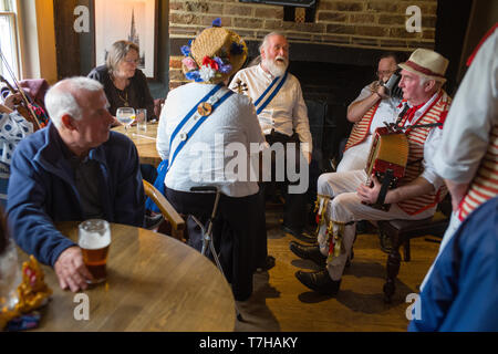 Thatxted Essex England UK. Morris Dancers traditionelle Singen im Swan Pub nach dem Tanz in der Kirche Parkplatz am Feiertag Montag. 6. Mai 2019 Stockfoto