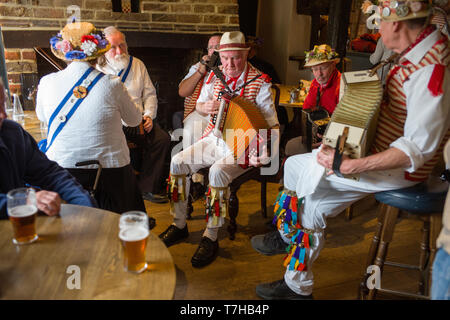 Thatxted Essex England UK. Morris Dancers traditionelle Singen im Swan Pub nach dem Tanz in der Kirche Parkplatz am Feiertag Montag. 6. Mai 2019 Stockfoto