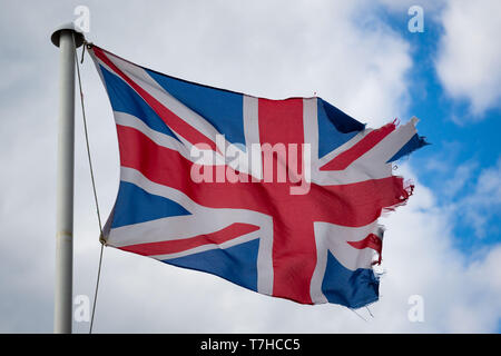 Eine zerrissene beschädigt GB Union Jack Flagge im Wind. Stockfoto