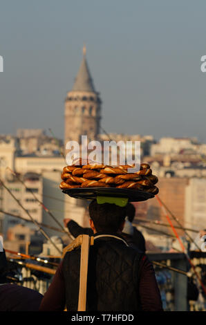 Ein türkischer Mann trägt Simit auf einem Tablett auf dem Kopf auf den Galataturm, Istanbul, Türkei Stockfoto