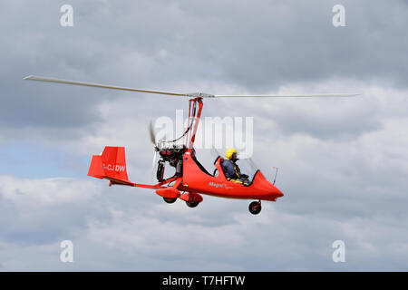 G-CJDW Eine helle rote Magni M16C gyrocopter steigt in Popham Flugplatz im Frühjahr Ultraleichtflugzeug aviation Fly-in Event Stockfoto