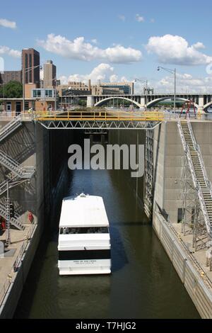 Ein Boot, das durch die obere St. Anthony Sperren und Damm auf dem Mississippi Fluss an St. Antonius fällt in Minneapolis, Minnesota