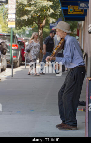 ASHEVILLE, North Carolina, USA - 9. September 2018: Eine ältere Geiger Solo spielt für Tipps auf einer belebten Zentrum von Asheville Straße am 9. September, 201 Stockfoto