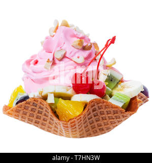 Frisch geschnittene Früchte im Waffle rosa Kegel Schüssel mit Sahne und Nüssen dekoriert maraschino Kirsche ist auf weißem Hintergrund Stockfoto