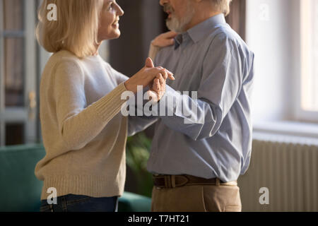 Paar mittleren Alters, liebevolle Frau und Mann tanzen zu Hause Stockfoto