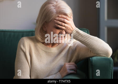 Unglücklich reife grau behaarte Frau leidet unter Kopfschmerzen Nahaufnahme Stockfoto